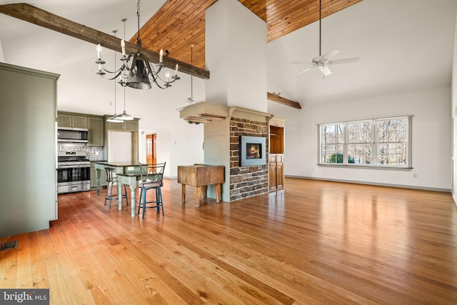 kitchen featuring tasteful backsplash, wood-type flooring, stainless steel appliances, green cabinets, and a fireplace