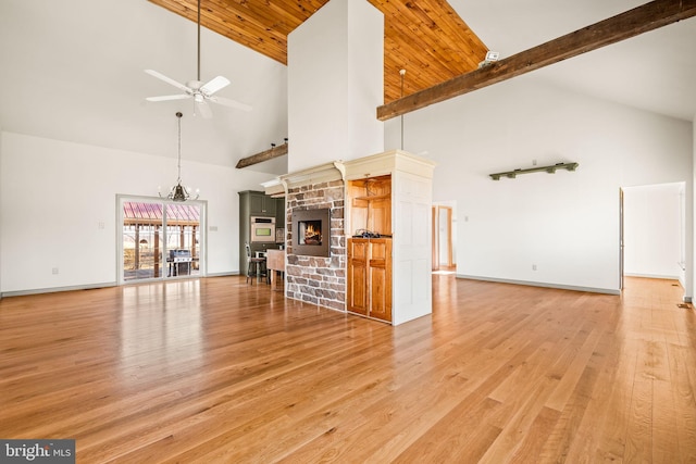 unfurnished living room with a fireplace, light hardwood / wood-style floors, ceiling fan, high vaulted ceiling, and beamed ceiling