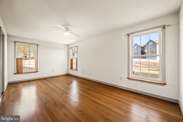 empty room with hardwood / wood-style flooring and ceiling fan