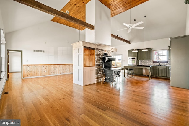 kitchen with light wood-type flooring, stainless steel oven, ceiling fan, high vaulted ceiling, and beam ceiling