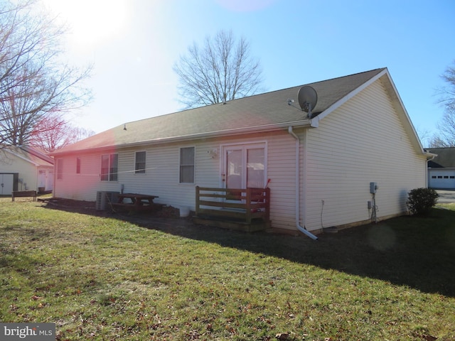 back of property featuring a lawn and central AC unit