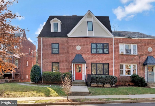 view of front facade with brick siding and a front yard