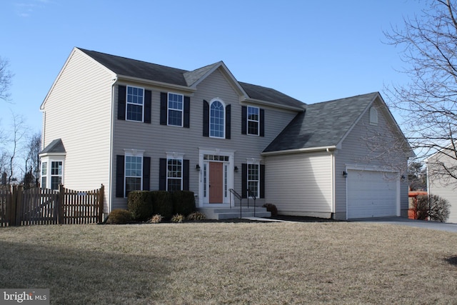 colonial-style house featuring a garage and a front lawn