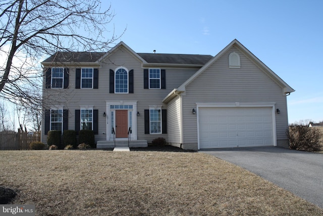 colonial inspired home with a front lawn and a garage