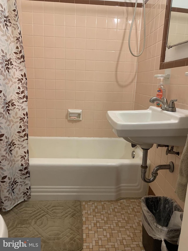 bathroom with tile walls, backsplash, and shower / bath combo