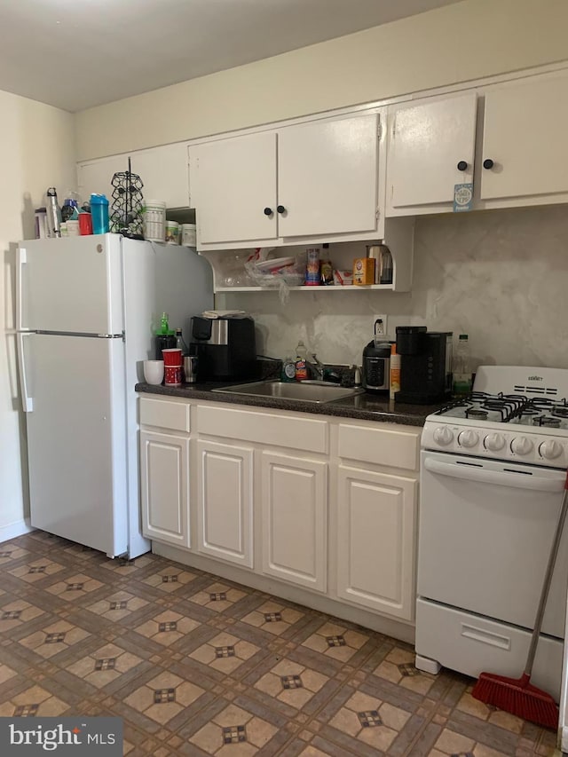 kitchen with white appliances, white cabinetry, sink, and backsplash