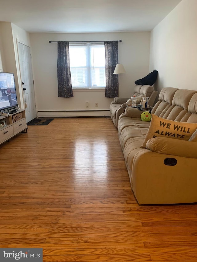 living room with light hardwood / wood-style floors and a baseboard heating unit