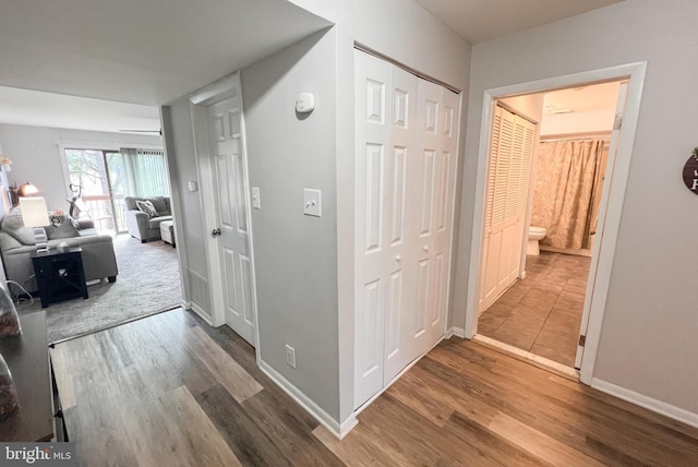 hall featuring wood finished floors and baseboards