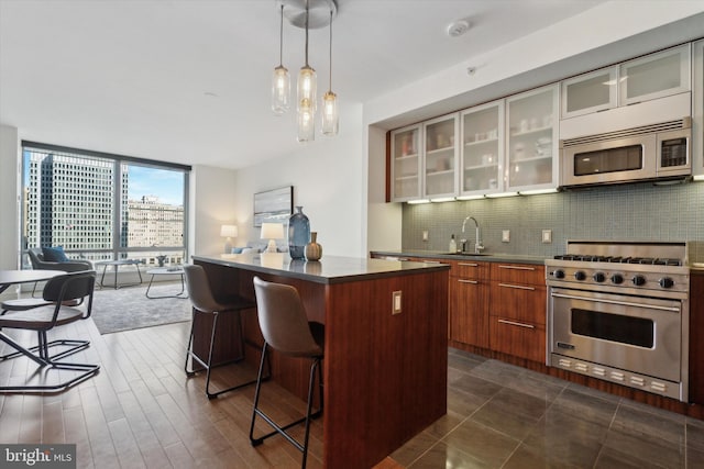 kitchen with expansive windows, appliances with stainless steel finishes, a kitchen breakfast bar, and decorative backsplash