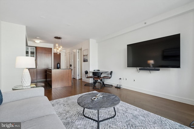 living room with dark wood-type flooring and a notable chandelier