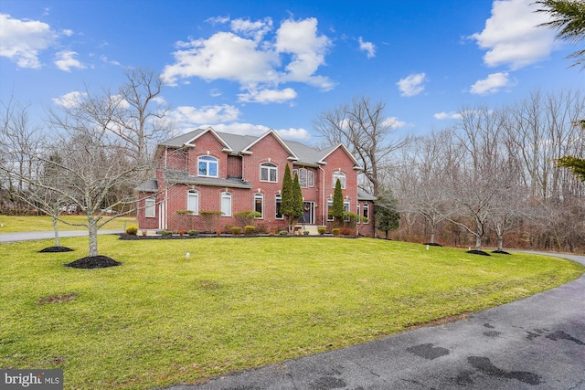 view of front of house with a front yard and brick siding