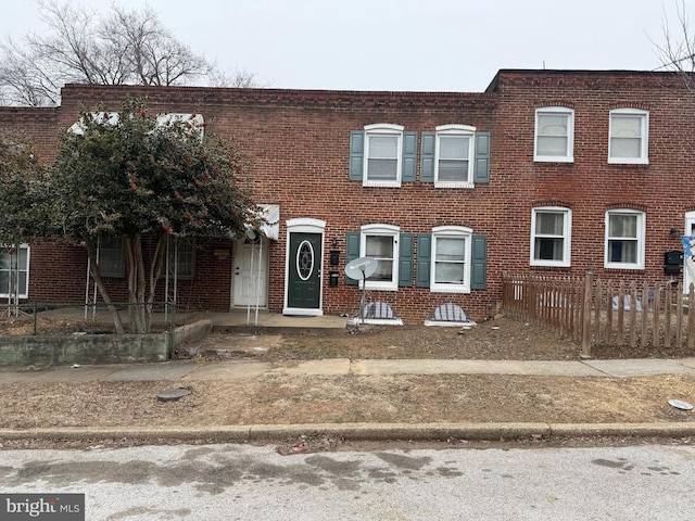 townhome / multi-family property featuring brick siding and fence