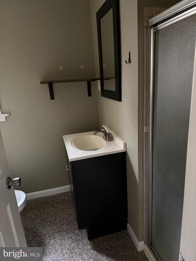 bathroom with a shower stall, baseboards, and vanity