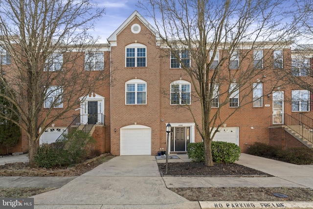 multi unit property featuring driveway, brick siding, and an attached garage