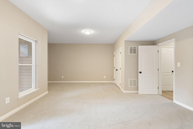 unfurnished bedroom featuring visible vents, light carpet, and baseboards