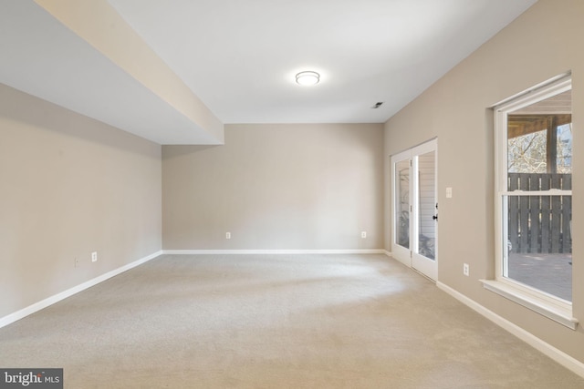 spare room with light carpet and baseboards