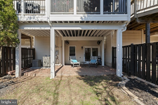 rear view of house with a patio, central AC unit, and fence