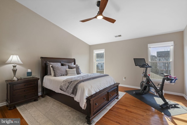 bedroom featuring lofted ceiling, baseboards, and light wood-style floors