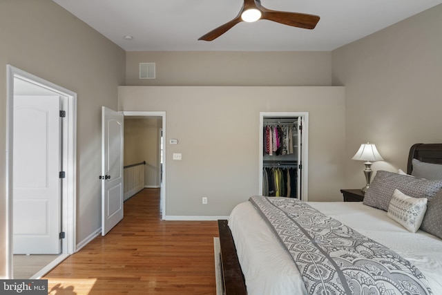 bedroom with a closet, visible vents, a spacious closet, light wood-style floors, and baseboards