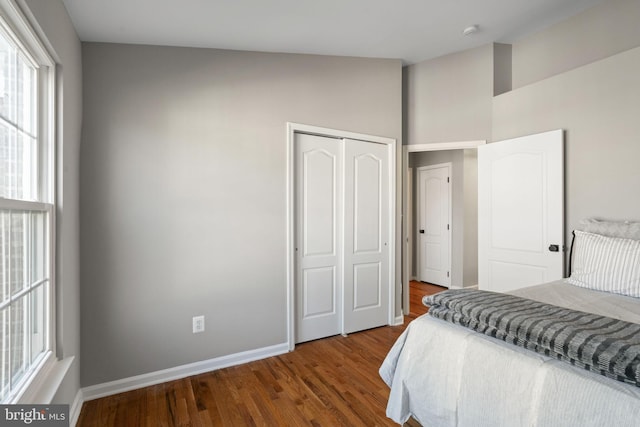 bedroom featuring a closet, baseboards, and wood finished floors