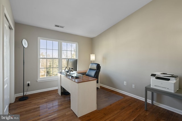 office featuring dark wood-style floors, lofted ceiling, visible vents, and baseboards