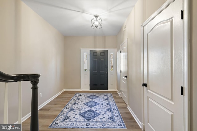 foyer entrance with wood finished floors and baseboards