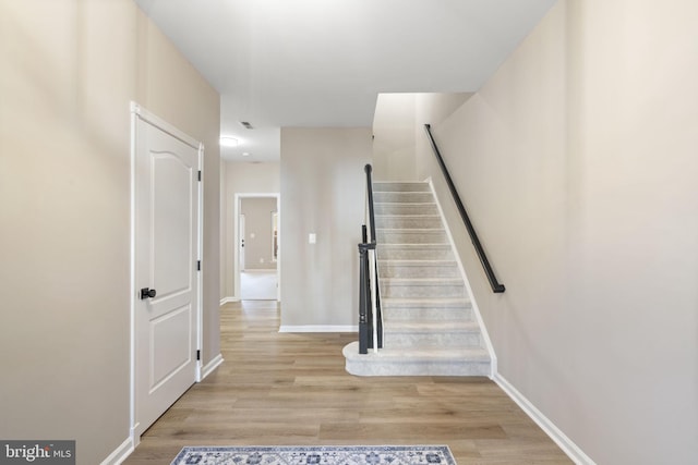 stairs with baseboards and wood finished floors