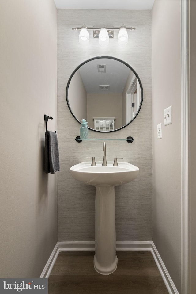 bathroom featuring wood finished floors, visible vents, and baseboards