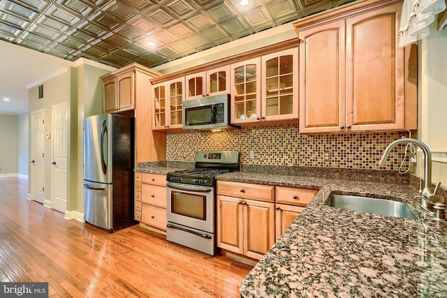 kitchen featuring stainless steel appliances, tasteful backsplash, a sink, and an ornate ceiling