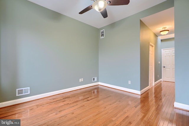 spare room featuring baseboards, visible vents, ceiling fan, and hardwood / wood-style floors