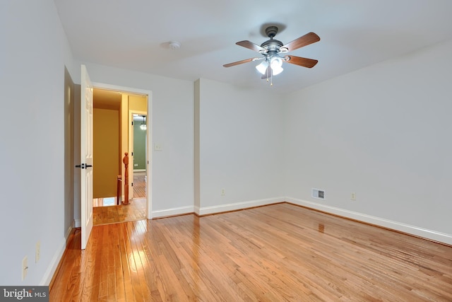 spare room with a ceiling fan, visible vents, light wood-style flooring, and baseboards