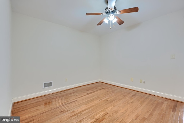 empty room with ceiling fan, light wood finished floors, visible vents, and baseboards