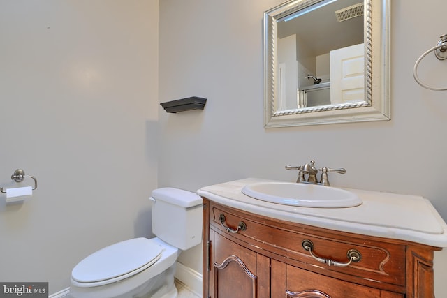 bathroom featuring toilet, baseboards, visible vents, and vanity