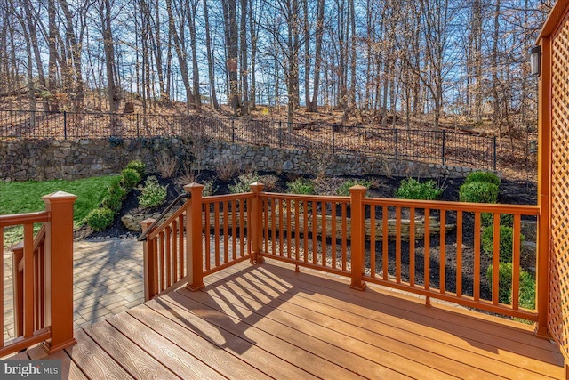 wooden terrace with a fenced backyard