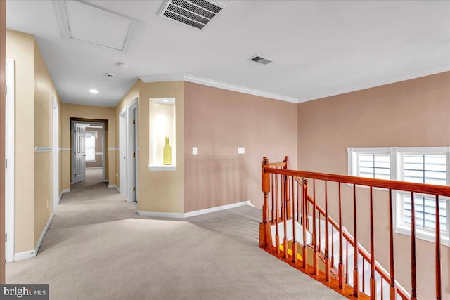 hall with carpet floors, visible vents, and an upstairs landing