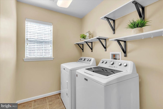 washroom with laundry area, light tile patterned floors, baseboards, and separate washer and dryer