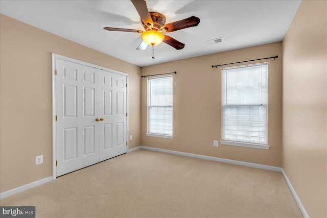 unfurnished bedroom featuring carpet floors, a closet, visible vents, and baseboards