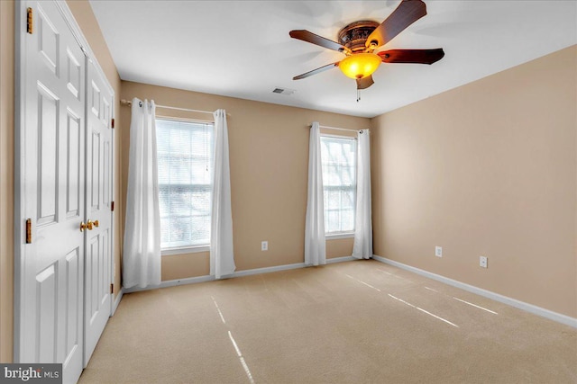 interior space featuring carpet floors, visible vents, baseboards, and a ceiling fan