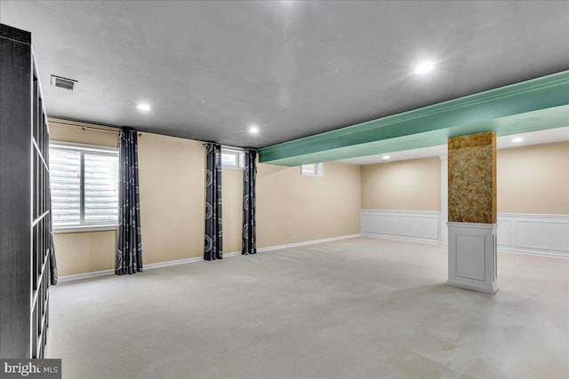 below grade area featuring recessed lighting, visible vents, a decorative wall, and light colored carpet