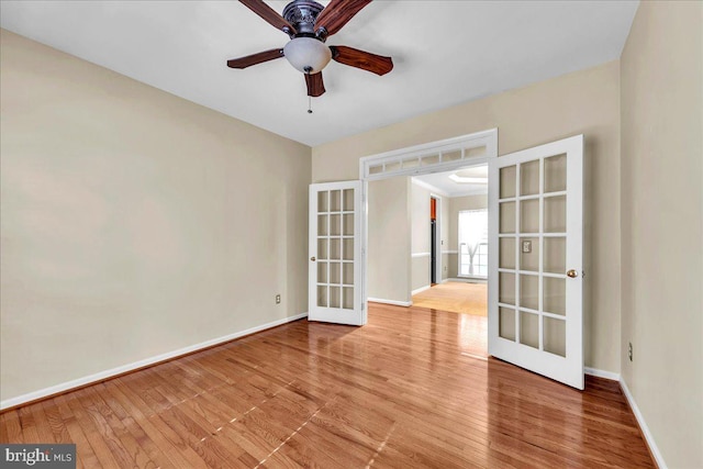 unfurnished room featuring french doors, wood-type flooring, a ceiling fan, and baseboards