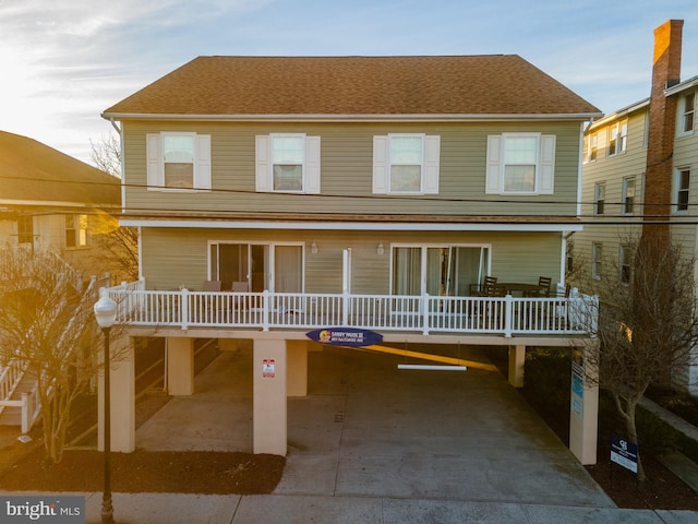 view of front of home with covered porch and roof with shingles