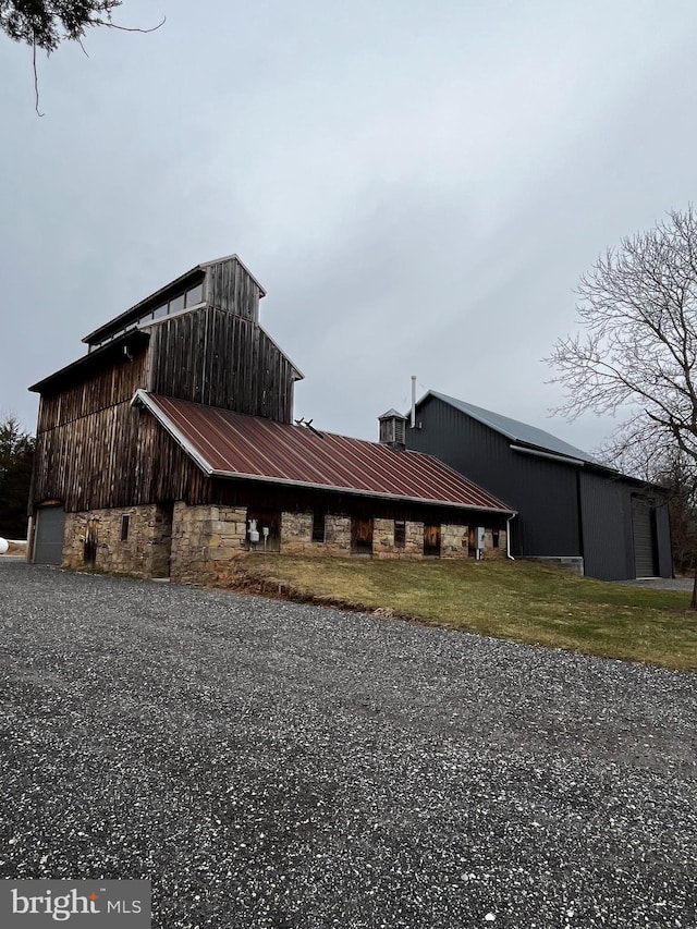 view of front of property featuring a front lawn and an outdoor structure