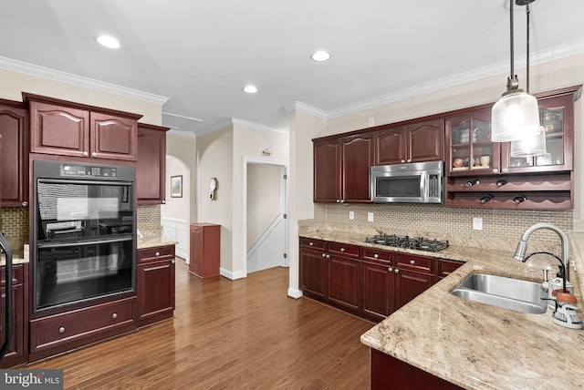 9801 Alydar Ct, Nokesville, VA 20181 - kitchen featuring light stone counters, dark wood-style floors, appliances with stainless steel finishes, arched walkways, and a sink