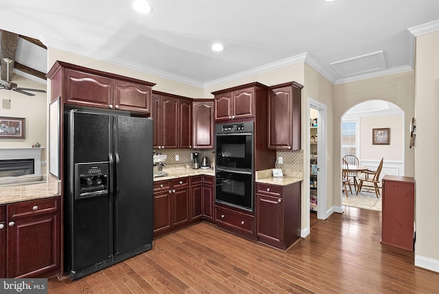 9801 Alydar Ct, Nokesville, VA 20181 - kitchen with arched walkways, dark wood-style flooring, ornamental molding, black appliances, and backsplash