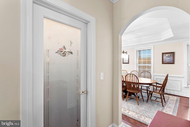 9801 Alydar Ct, Nokesville, VA 20181 - entrance foyer with arched walkways, dark wood-type flooring, wainscoting, crown molding, and a decorative wall