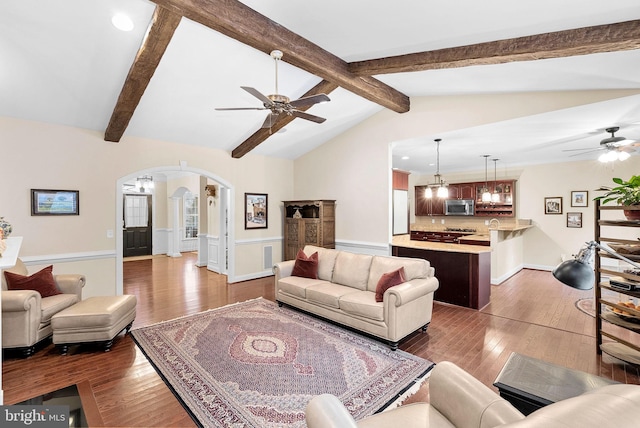 9801 Alydar Ct, Nokesville, VA 20181 - living room featuring vaulted ceiling with beams, ceiling fan, a wainscoted wall, arched walkways, and wood-type flooring