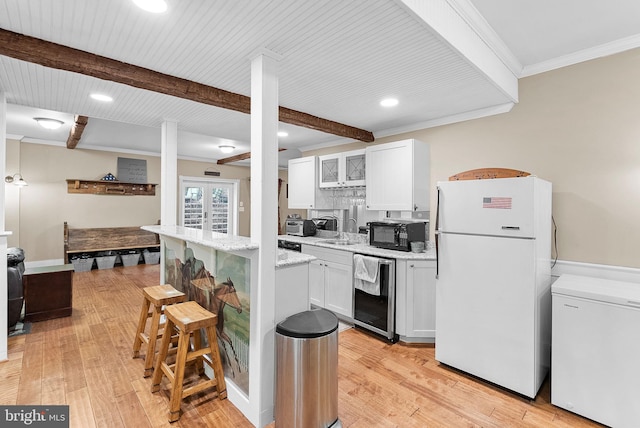 9801 Alydar Ct, Nokesville, VA 20181 - kitchen featuring light wood-style flooring, refrigerator, freestanding refrigerator, a breakfast bar area, and black microwave