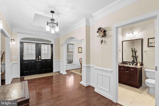 9801 Alydar Ct, Nokesville, VA 20181 - foyer with arched walkways, french doors, wainscoting, light wood-type flooring, and a chandelier