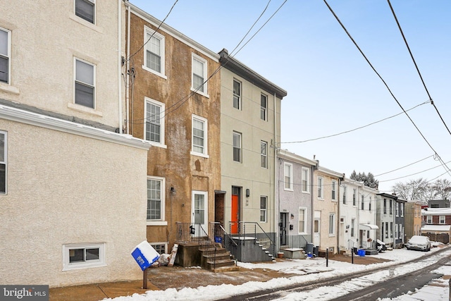 snow covered property with central AC unit