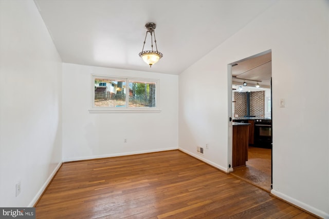 unfurnished dining area with wood-type flooring and baseboards